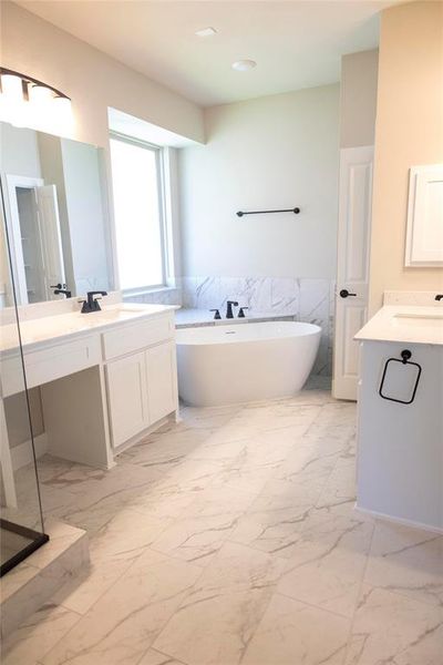 Bathroom with dual vanity, tile walls, a bath, and tile patterned floors