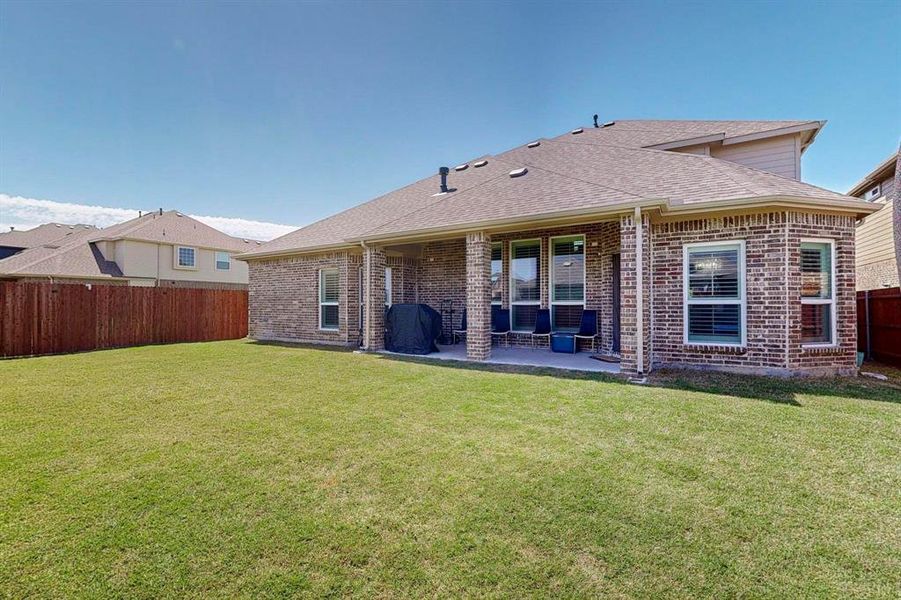 Back of property featuring a yard and a patio area