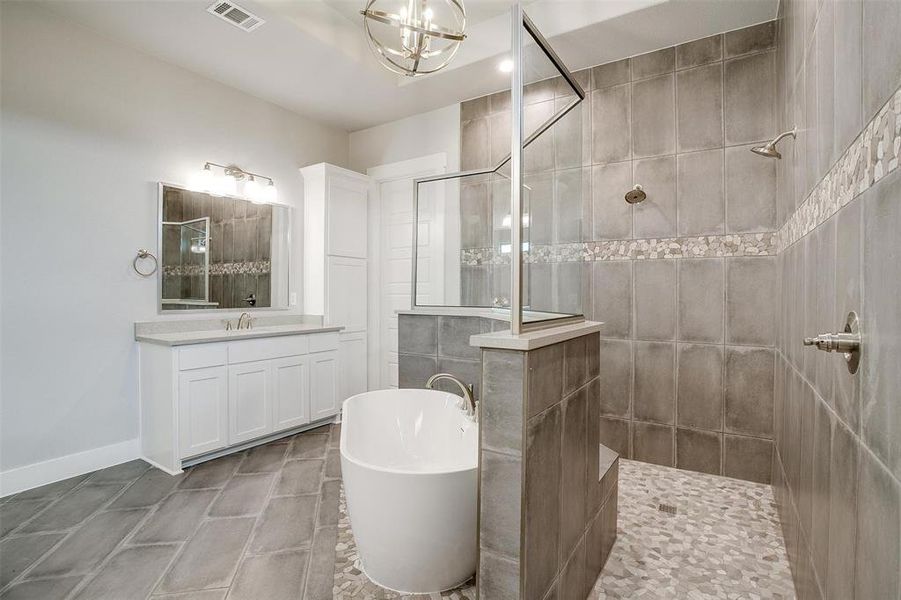 Bathroom with vanity, shower with separate bathtub, tile walls, tile floors, and a chandelier