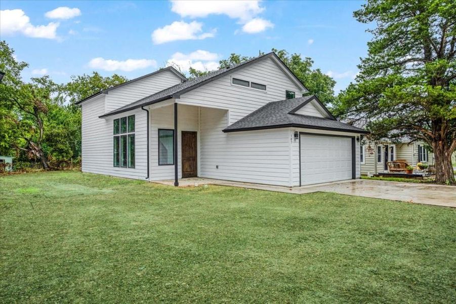 View of front of property featuring a front yard and a garage