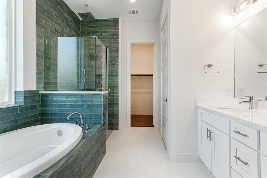 Bathroom featuring vanity, tile patterned floors, and shower with separate bathtub