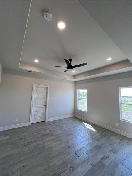 Unfurnished room with a tray ceiling, ceiling fan, and hardwood / wood-style flooring