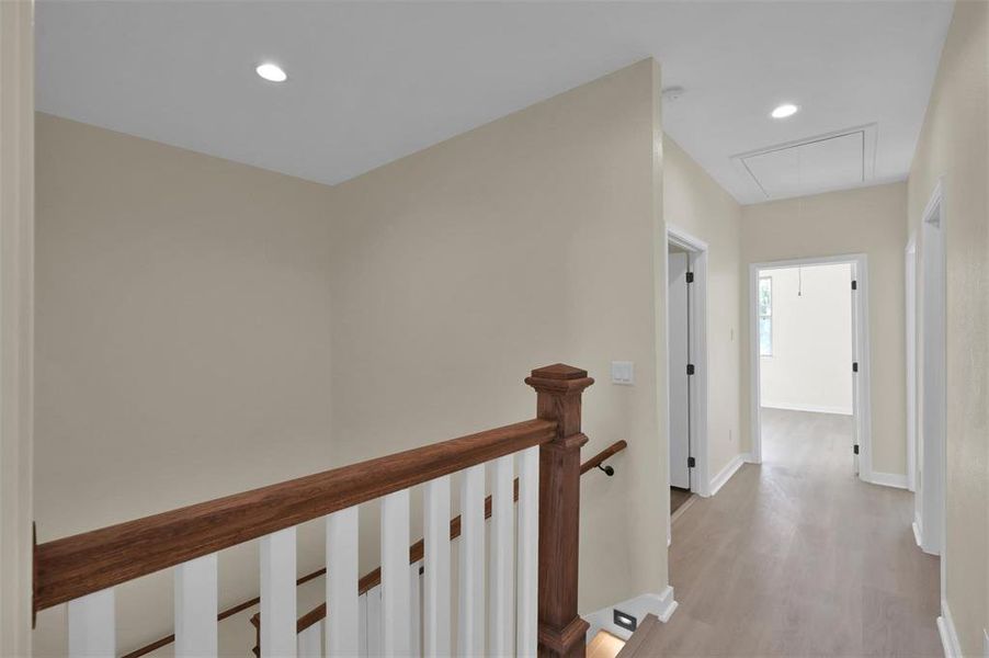 Second floor landing with hallway to guest bedrooms, full bath, laundry room and primary bedroom.