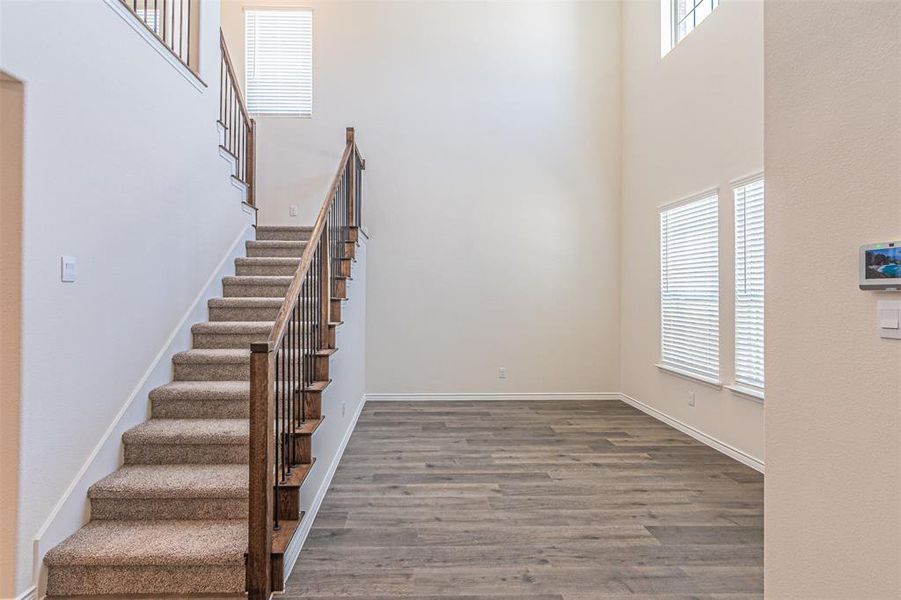 Stairway featuring wood-type flooring and a high ceiling