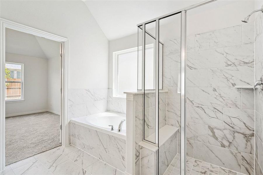 Bathroom with lofted ceiling, separate shower and tub, and tile patterned flooring