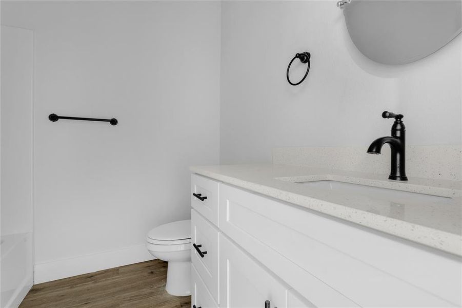 Bathroom featuring a bathing tub, hardwood / wood-style floors, vanity, and toilet