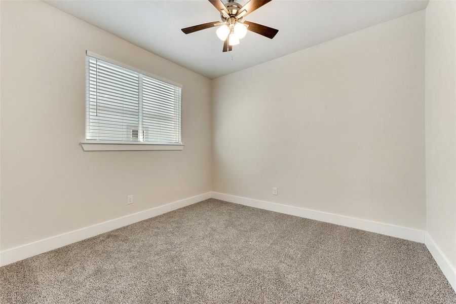 Carpeted empty room featuring ceiling fan