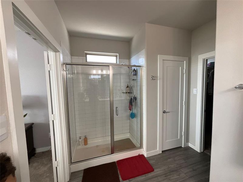 Bathroom with a shower with door and hardwood / wood-style floors