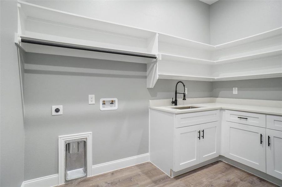 Laundry room with electric dryer hookup, sink, light hardwood / wood-style flooring, and hookup for a washing machine