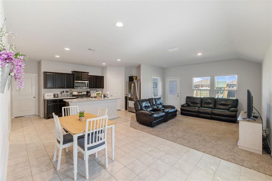 Living room with vaulted ceiling and light colored carpet