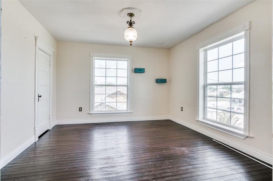 Spare room featuring dark wood-type flooring