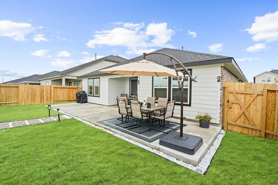 Spacious backyard with a manicured lawn, and recently added 40X10 concrete patio area featuring a privacy fence. Ideal for outdoor relaxation and entertainment.