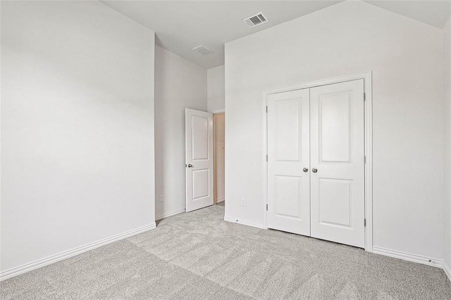 Unfurnished bedroom featuring light carpet and a closet