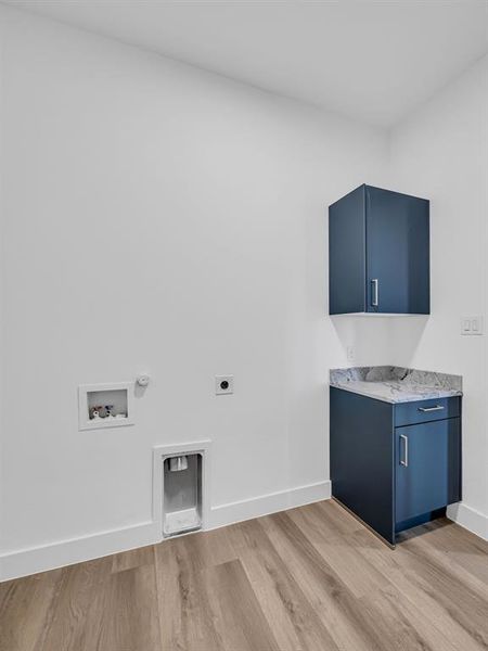 Laundry room featuring cabinets, washer hookup, hookup for a gas dryer, hookup for an electric dryer, and light hardwood / wood-style floors