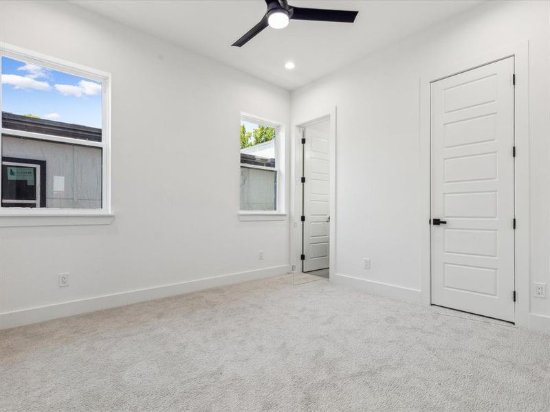 Unfurnished bedroom featuring ceiling fan and carpet floors