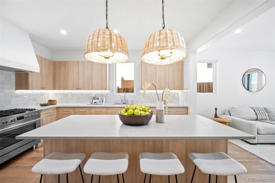 Eat-in kitchen island illumated by designer light fixtures