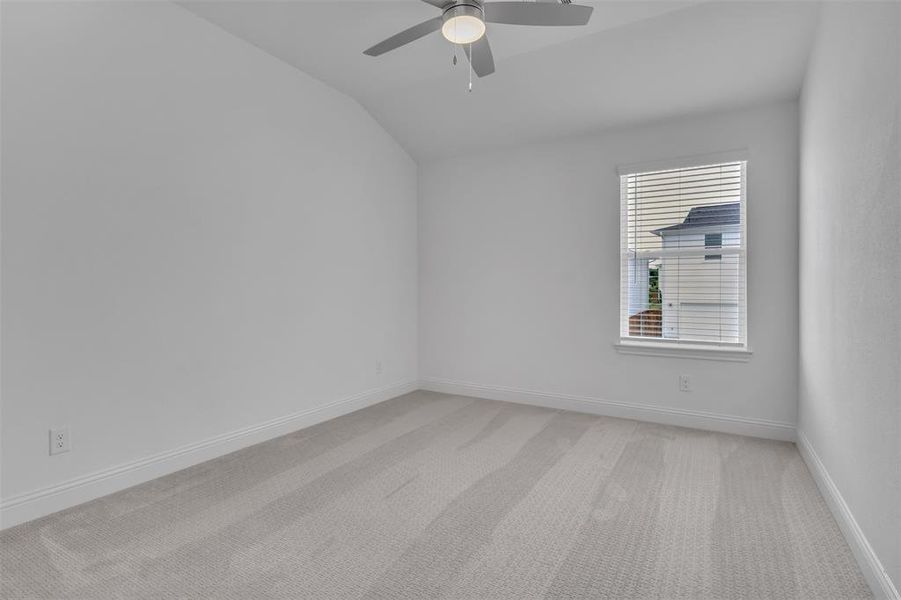 Unfurnished room featuring carpet, ceiling fan, and lofted ceiling