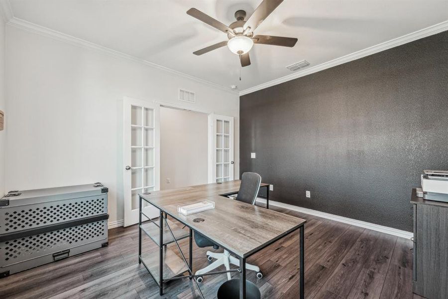 Office featuring dark wood-type flooring, ceiling fan, french doors, and ornamental molding