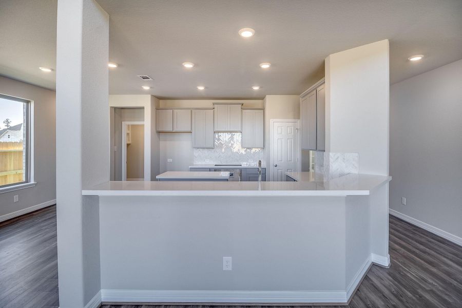 Kitchen open to family and dining rooms. Note: Sample product photo - actual exterior and interior selections may vary by homesite