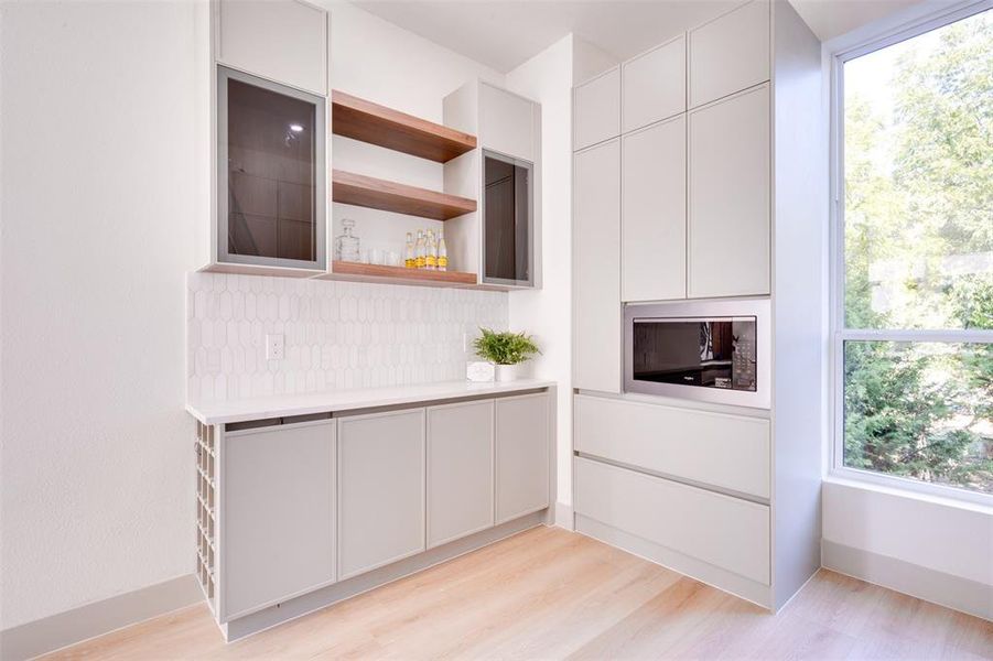 Kitchen featuring a wealth of natural light, white cabinetry, and light hardwood / wood-style floors