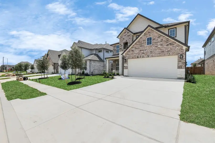 The residence features a practical 2-car garage complemented by a generous driveway, ensuring abundant space for parking needs.