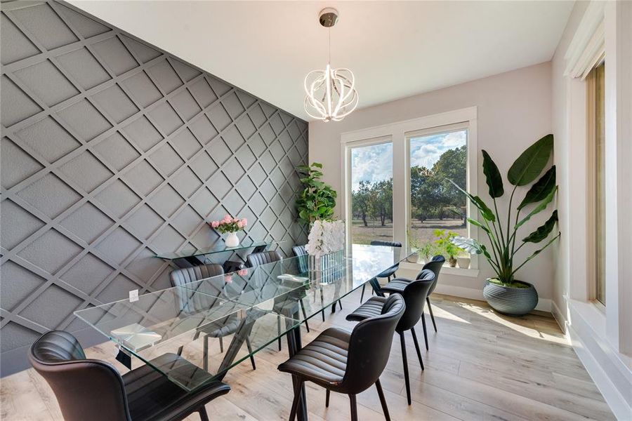 Dining space featuring light wood-type flooring and an inviting chandelier