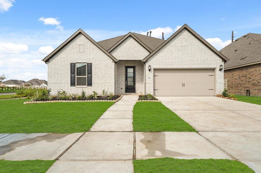 Corner Lot! Beautiful 4 Bedroom 3 Bathroom 2731 Sq Ft single-story brick home featuring a two-car garage, a well-manicured lawn, and a unique landscaping design.