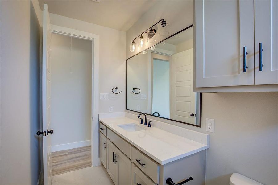 Bathroom featuring tile floors, toilet, and large vanity