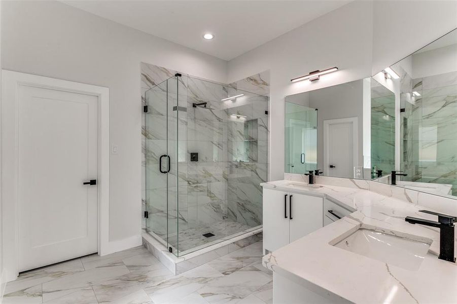 Bathroom featuring walk in shower, tile flooring, dual sinks, and large vanity