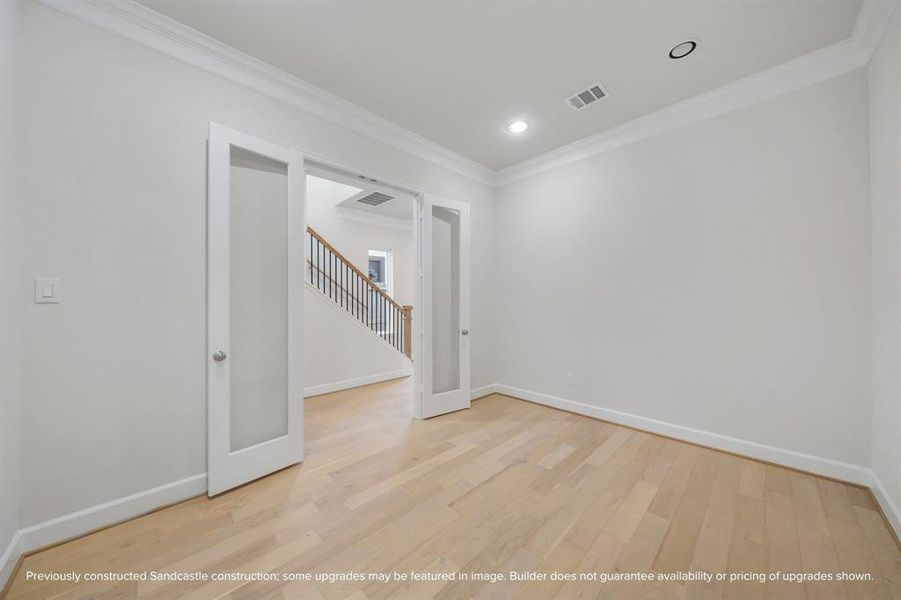 Elegant double doors with glass insets offer a charming view of the foyer, adding sophistication to your study.