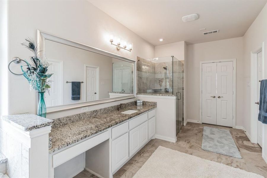 Bathroom featuring vanity, tile patterned flooring, and walk in shower