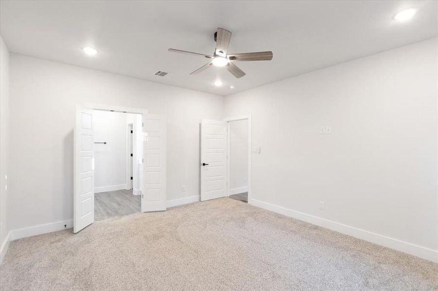 Unfurnished bedroom featuring light carpet and ceiling fan