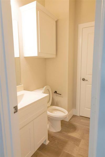 Bathroom with wood-type flooring, toilet, and vanity