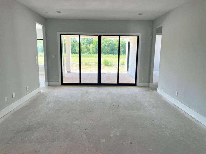 The gameroom features a wall of windows that open to 1 of 2 covered patios.