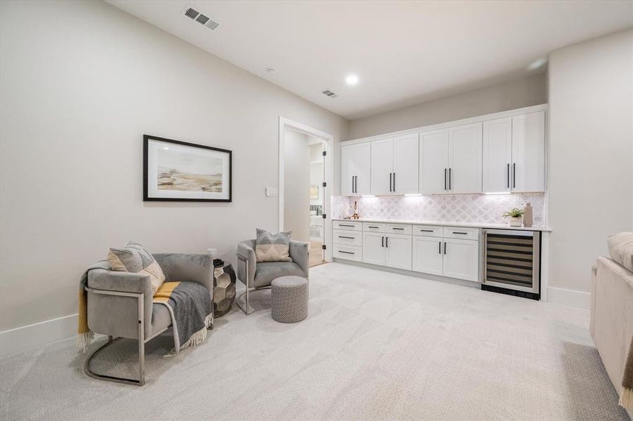 Sitting room featuring beverage cooler and light colored carpet