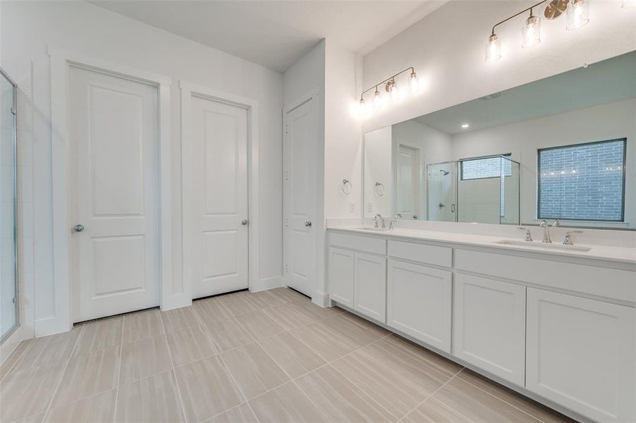 Bathroom featuring vanity, tile patterned floors, and an enclosed shower