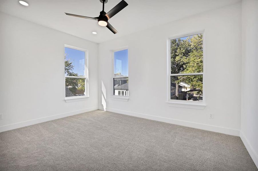 Empty room featuring ceiling fan and carpet floors