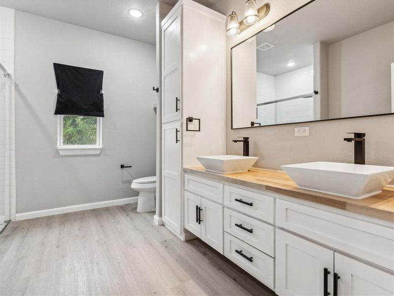 Bathroom featuring an enclosed shower, wood-type flooring, toilet, and vanity