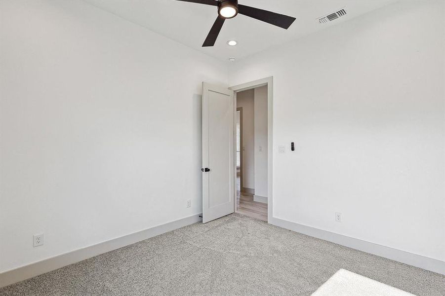 Carpeted empty room featuring ceiling fan