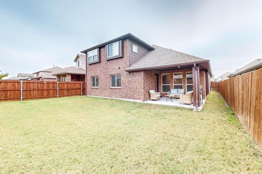 Rear view of house with outdoor lounge area, a lawn, and a patio