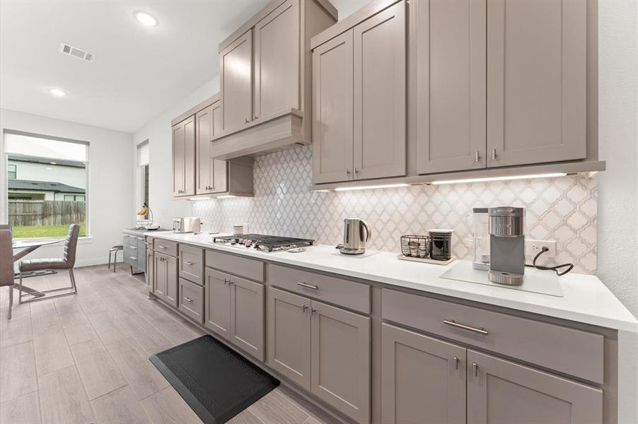 Workstation lighting under the cabinets ensures ample illumination for meal prep and cooking.