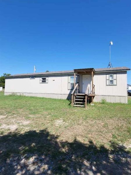 Rear view of property with a yard