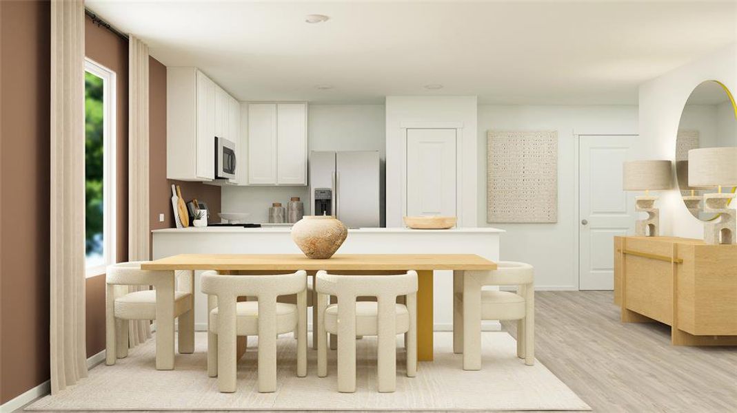 Kitchen featuring light hardwood / wood-style flooring, fridge with ice dispenser, and white cabinets