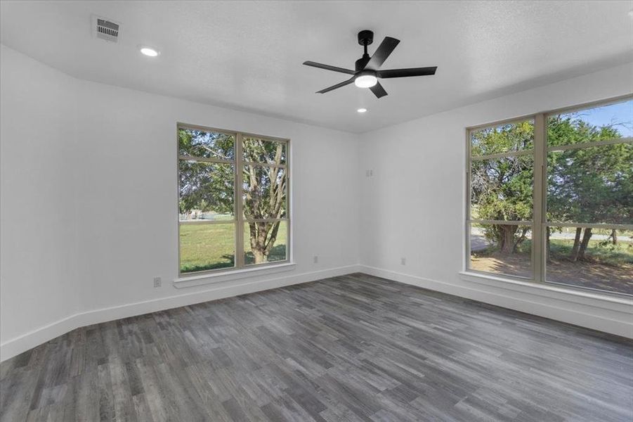 Unfurnished room with a wealth of natural light and dark wood-type flooring