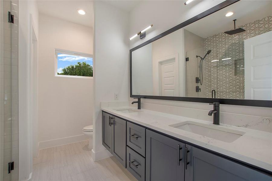 Bathroom featuring toilet, a shower with door, and vanity