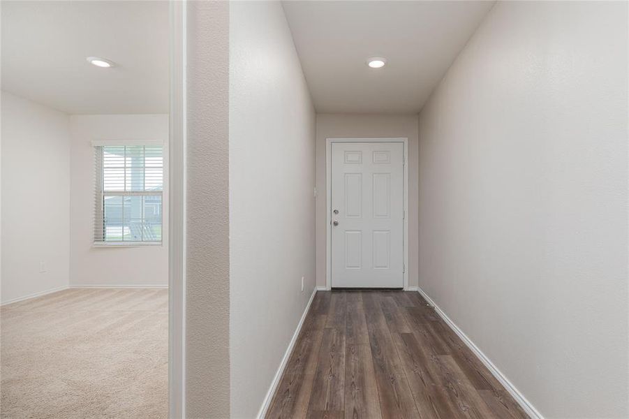 Hall featuring dark colored carpet