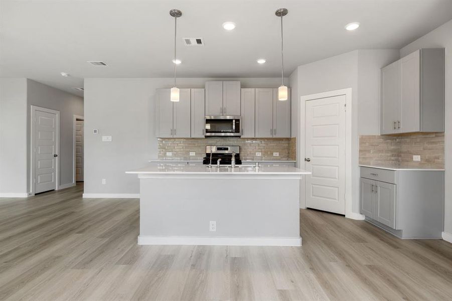 This kitchen is by far any chef’s dream! This spacious kitchen features high ceilings, grey wood cabinets, Quartz countertops, SS appliances, modern tile backsplash, recessed lighting with additional custom pendant lighting, extended counter space, Quartz kitchen island with double sink and space for breakfast bar and a walk-in pantry all overlooking your huge family room.