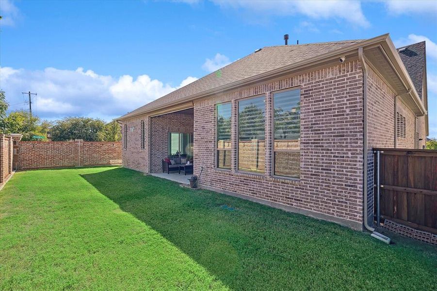 Rear view of house with a yard and a patio