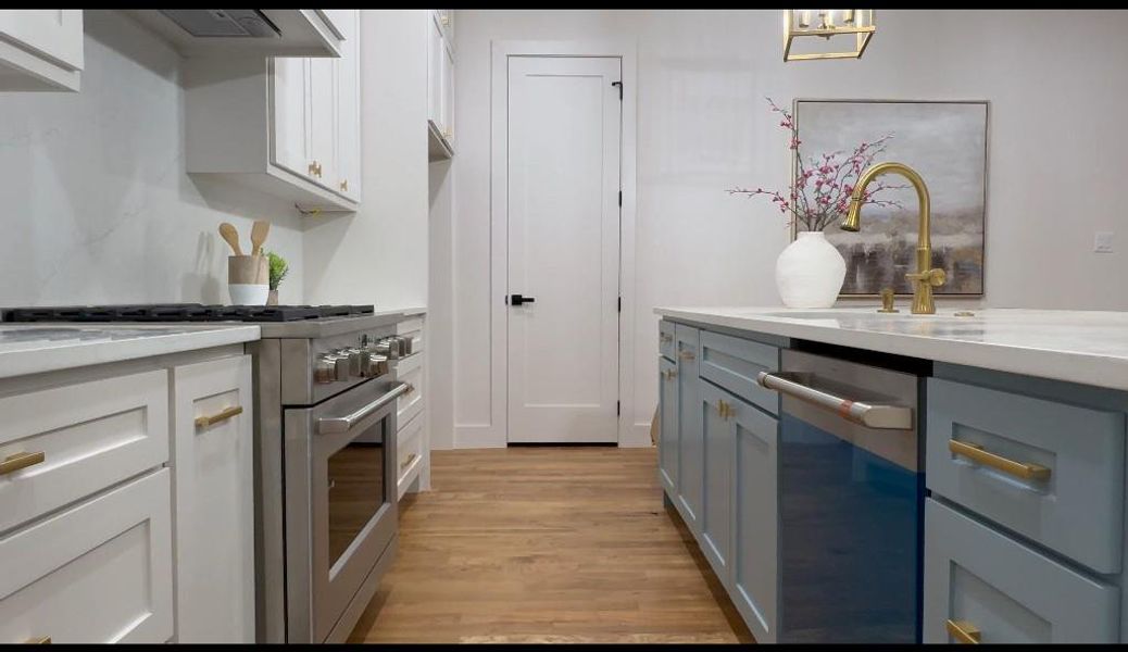 Kitchen with white cabinets, dishwashing machine, gray cabinets, light wood-type flooring, and high end stainless steel range