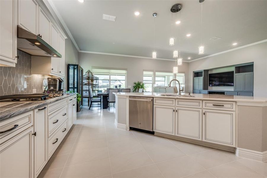 Kitchen with pendant lighting, light tile patterned floors, appliances with stainless steel finishes, tasteful backsplash, and sink